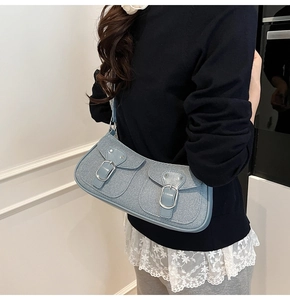 Detail der hellblauen gewebten Baguette-Tasche mit Doppeltaschen und silbernen Schnallen