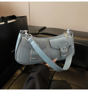Detailaufnahme der hellblauen Denim-Baguette-Tasche mit Doppeltaschen und Silberschnallen