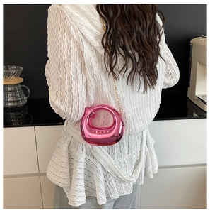 Mini borsa da sera rosa metallizzato con tracolla a catena indossata da modella