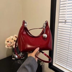 Chic burgundy patent leather dumpling bag with silver hardware and spherical pendant detail