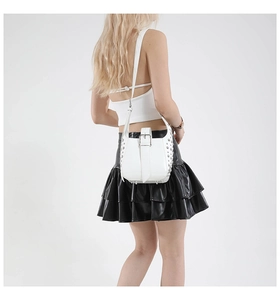 Détail d'un sac seau blanc avec rivets argentés et large boucle au style punk Y2K
