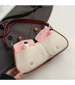 Detail der Canvas-Schultertasche mit rosa Ledertaschen und silbernen Metallschnallen