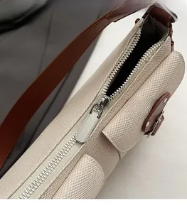 Detailaufnahme des silbernen Reißverschlusses und des strukturierten beigen Taschenmaterials