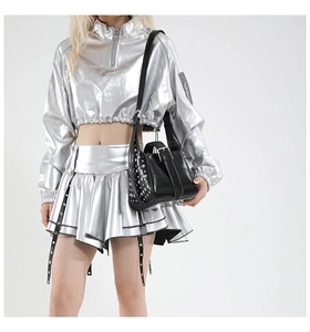 Détail d'un sac seau punk noir à rivets argentés porté par un mannequin en tenue argent