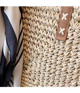 Macro detail of large woven straw tote bag with brown leather accents and striped silk scarf