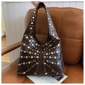 Detailed texture of dark brown leather hobo bag with silver butterfly rivet patterns