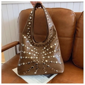 Detailed close-up of brown faux leather hobo bag featuring silver metal stud embellishments