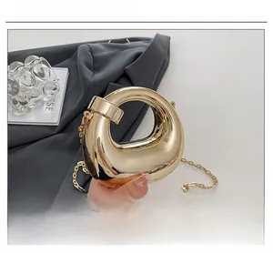 Detailed close-up of a high-end gold irregular geometric evening bag with a metal chain