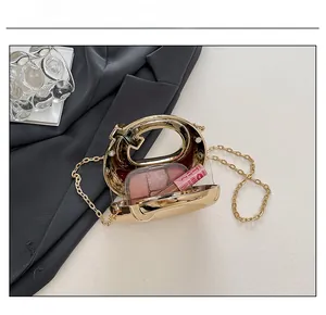 Detail showing the internal capacity of the golden acrylic dinner bag with small cosmetics