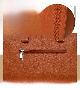 Close-up of litchi-grain leather tote with metal zipper and braided stitch details
