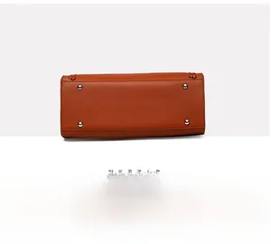 Close-up of brown pebbled leather tote bag bottom with protective metal studs