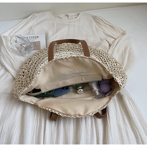 Detailed macro view of woven beach bag interior with leather strap and linen lining