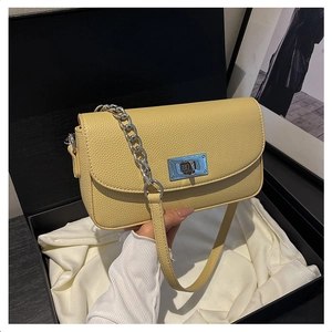 Detail of cream yellow lychee leather bag with silver chain strap and metal lock