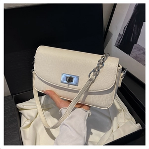 Detail of cream lychee leather handbag with silver rotary buckle and chain strap