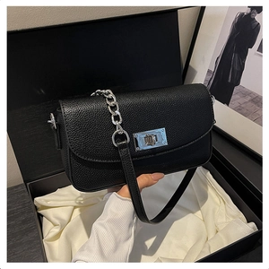 Detail of black lychee leather crossbody bag with silver square twist lock in a gift box