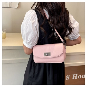 Detail of pink lychee grain leather handbag with silver twist lock on female model