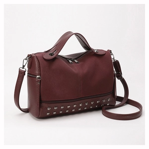 Detail view of burgundy leather Boston bag with silver rivets and textured stitching