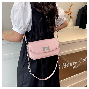 Pink lychee grain leather crossbody bag detail with silver turn-lock and chain strap