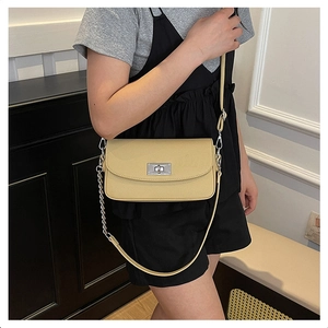 Detail of light yellow lychee pattern leather handbag with silver rotating lock buckle