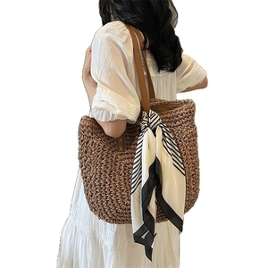 Large woven tote bag with brown leather straps and black-white striped silk scarf detail