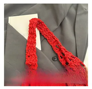 Macro view of red hollow knit shoulder bag showing thick reinforced handle and texture