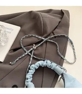 Detail of light blue pleated bag with silver chain strap and metal ball adjuster