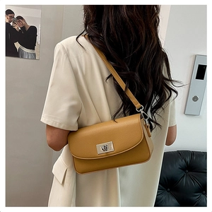 Close-up of brown litchi pattern leather shoulder bag with silver metal twist lock