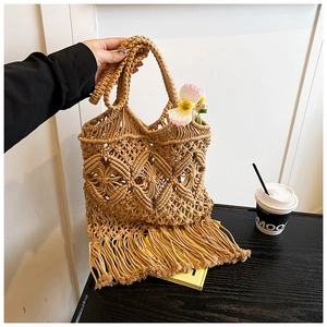 Détail d'un sac bohème en paille tressée avec maille ajourée et longues franges