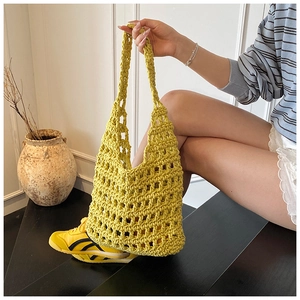 Detail of yellow hollow knit shoulder bag with handmade mesh texture and sturdy handles
