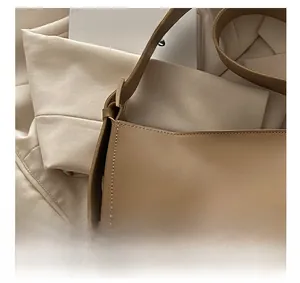 Detailed view of beige faux leather texture and stitching on an oversized tote bag