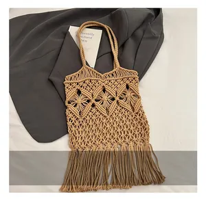 Détail du motif ajouré en paille tressée et des longues franges sur le sac d'été