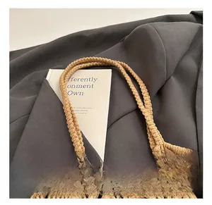 Détail des poignées tissées renforcées d'un grand sac de plage en paille beige