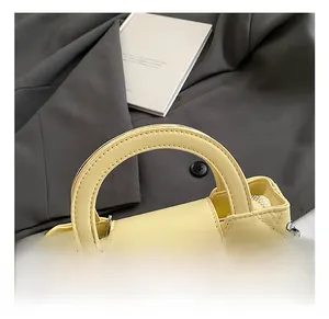 Detail showing yellow quilted handbag with silver rhinestones and rigid top handle
