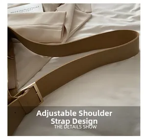 Detail of adjustable khaki faux leather strap with pale gold metal buckle on tote bag
