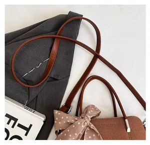 Détail de la bandoulière marron confortable sur un sac cabas avec un nœud à pois chic