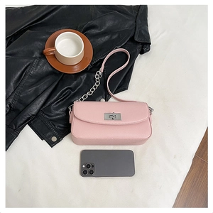 Detail of light pink lychee pattern crossbody bag with silver twist lock and chain strap