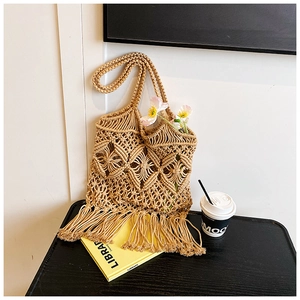 Vue détaillée du sac cabas en paille ajouré avec franges et motif tissé bohème
