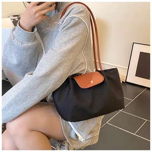 Detail of classic black nylon tote with brown leather handles and gold snap button