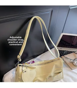 Dettaglio tracolla regolabile e ciondolo a cuore su borsa tote in pelle sintetica