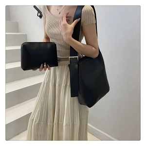 Detail of minimalist black tote bag with matching pouch and silver adjustable buckle strap