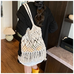 Détail du sac en paille macramé blanc avec des franges et une texture en maille ajourée