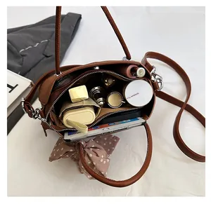 Vue intérieure du sac bandoulière en cuir marron montrant sa grande capacité de rangement