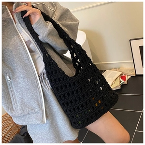 Detail of black crochet mesh shoulder bag showing intricate hollow knit texture and strap