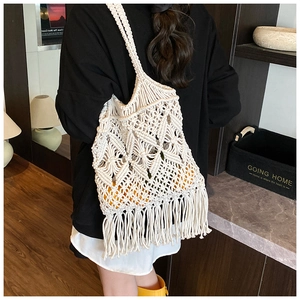 Détail d'un sac en paille tissé ajouré avec glands et motif à larges mailles