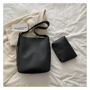 Detail of minimalist black faux leather tote bag and matching inner zipper pouch set