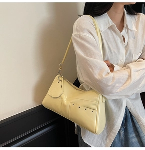 Dettaglio borsa shopper giallo chiaro con borchie argentate e ciondolo cuore in pelle