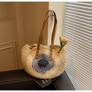 Handmade woven straw tote bag with blue gradient circular pattern for beach vacations