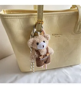 Detail eines süßen Teddybär-Anhängers mit Kordel an einer Tragetasche für Damen