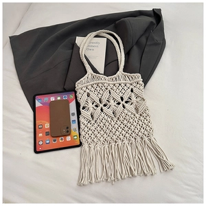 Détail d'un sac bohème en macramé crème avec tricot évidé complexe et longues franges