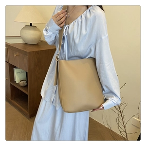 Minimalist beige tote bag shown with casual outfit in a cozy indoor lifestyle setting